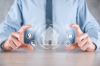 İş adamı ev ikonunu tutuyor. Marketin ev kontrollü, akıllı ev ve ev otomasyon uygulaması konsepti. PCB tasarımı ve akıllı telefonu olan kişi. Yenilik teknolojisi internet ağı kavramı