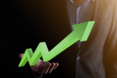 İş adamı artan ekran grafiği, pozitif büyüme ikonu okları üzerinde duruyor. Yaratıcı iş grafiğine yükselen oklarla işaret ediyor. Finansal, ticari büyüme kavramı.