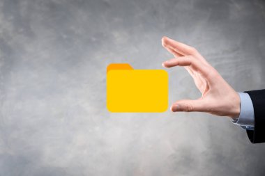 İş adamı dizin simgesini tutuyor. Belge Yönetim Sistemi veya modern bilgisayar bilişim danışmanı tarafından kurulmuş DMS yönetici dosyaları ve kurumsal dosyaları arıyor. İş işleme