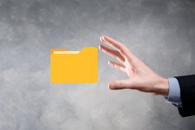 İş adamı dizin simgesini tutuyor. Belge Yönetim Sistemi veya modern bilgisayar bilişim danışmanı tarafından kurulmuş DMS yönetici dosyaları ve kurumsal dosyaları arıyor. İş işleme