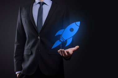 Soyut dijital roket ikonu taşıyan iş adamı konsepti fırlatılıyor ve yükseliyor.