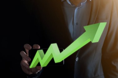 İş adamı artan ekran grafiği, pozitif büyüme ikonu okları üzerinde duruyor. Yaratıcı iş grafiğine yükselen oklarla işaret ediyor. Finansal, ticari büyüme kavramı.