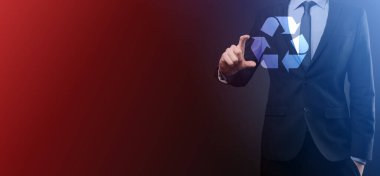 Takım elbiseli bir işadamı elinde bir geri dönüşüm simgesi tutuyor. Ekoloji, çevre ve koruma kavramı. Neon kırmızı mavi ışık.