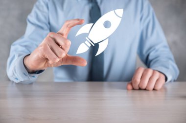 Soyut dijital roket ikonu taşıyan iş adamı konsepti fırlatılıyor ve yükseliyor.