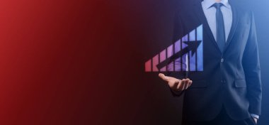 Holografik grafikler ve borsa istatistikleri tutan işadamı kâr elde ediyor. Büyüme planlama ve iş stratejisi kavramı. İyi ekonomi formunun dijital ekran görüntüsü