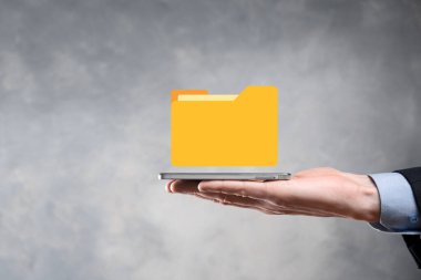 İş adamı dizin simgesini tutuyor. Belge Yönetim Sistemi veya modern bilgisayar bilişim danışmanı tarafından kurulmuş DMS yönetici dosyaları ve kurumsal dosyaları arıyor. İş işleme