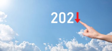 2021 yılında iş negatif büyüme planı. İşadamı planında ve işinde olumsuz göstergelerde artış, iş kavramlarını düşürme. Gökyüzü arka planında elle tutunma.