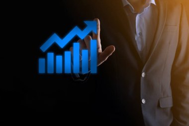 İş adamı elinde pozitif kar artışı olan bir grafik tutuyor. Grafik büyümesi ve grafik artışı işlerinde olumlu göstergeler. Daha kârlı ve büyüyen