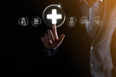 İş adamının elinde sanal ve tıbbi ağ bağlantısı simgeleri var. Covid-19 salgını insanları bilinçlendirir ve sağlık hizmetlerine dikkat çeker. Doktor, belge, ilaç, ambulans, hasta ikonu