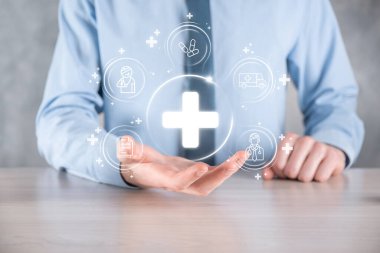 İş adamının elinde sanal ve tıbbi ağ bağlantısı simgeleri var. Covid-19 salgını insanları bilinçlendirir ve sağlık hizmetlerine dikkat çeker. Doktor, belge, ilaç, ambulans, hasta ikonu