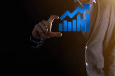 İş adamı elinde pozitif kar artışı olan bir grafik tutuyor. Grafik büyümesi ve grafik artışı işlerinde olumlu göstergeler. Daha kârlı ve büyüyen