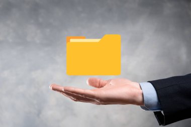 İş adamı dizin simgesini tutuyor. Belge Yönetim Sistemi veya modern bilgisayar bilişim danışmanı tarafından kurulmuş DMS yönetici dosyaları ve kurumsal dosyaları arıyor. İş işleme