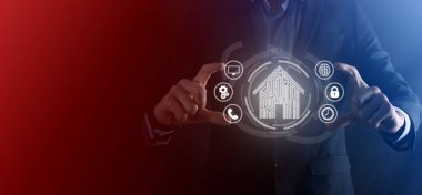 İş adamı ev ikonunu tutuyor. Marketin ev kontrollü, akıllı ev ve ev otomasyon uygulaması konsepti. PCB tasarımı ve akıllı telefonu olan kişi. Yenilik teknolojisi internet ağı kavramı