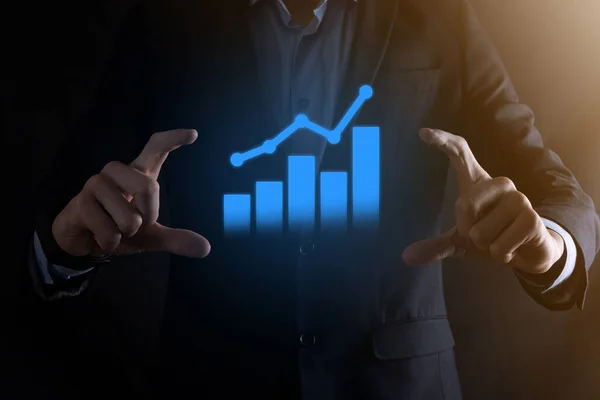 Businessman man holding a graph with positive profits growth. plan graph growth and increase of chart positive indicators in his business.more profitable and growing