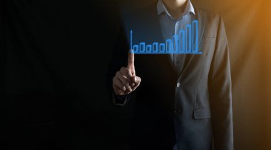 Holografik grafikler ve borsa istatistikleri tutan işadamı kâr elde ediyor. Büyüme planlama ve iş stratejisi kavramı. İyi ekonomi formunun dijital ekran görüntüsü