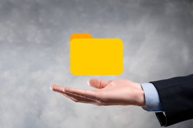 İş adamı dizin simgesini tutuyor. Belge Yönetim Sistemi veya modern bilgisayar bilişim danışmanı tarafından kurulmuş DMS yönetici dosyaları ve kurumsal dosyaları arıyor. İş işleme