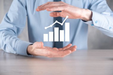İş adamı artan ekran grafiği, pozitif büyüme ikonu okları üzerinde duruyor. Yaratıcı iş grafiğine yükselen oklarla işaret ediyor. Finansal, ticari büyüme kavramı.