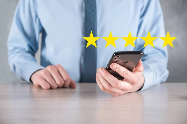 Man hand smartphone showing on five star excellent rating.pointing five star symbol to increase rating of company.Review, increase rating or ranking, evaluation and classification concept