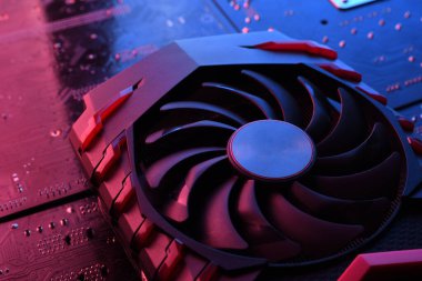 Bilgisayar oyunu grafikleri kartı, devre kartında iki soğutucu olan video oyunu, anakart geçmişi. Yakın plan. Kırmızı-mavi ışıkla.