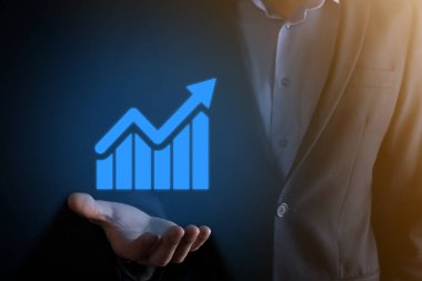 İş adamı elinde pozitif kar artışı olan bir grafik tutuyor. Grafik büyümesi ve grafik artışı işlerinde olumlu göstergeler. Daha kârlı ve büyüyen