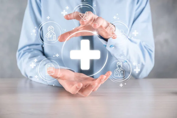 Businessman hold virtual plus medical network connection icons. Covid-19 pandemic develop people awareness and spread attention on their healthcare.Doctor,document,medicine,ambulance,patient icon
