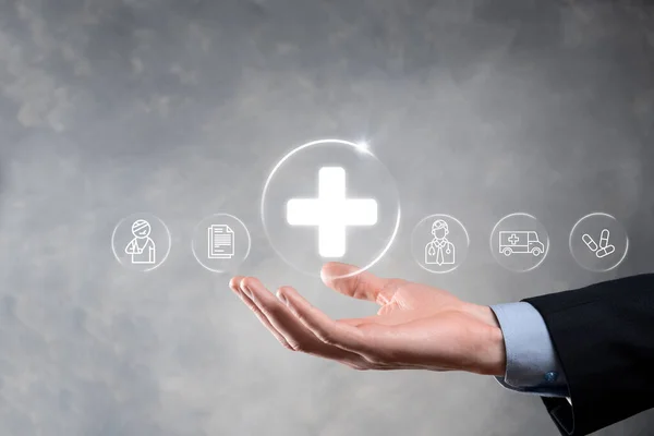 Businessman hold virtual plus medical network connection icons. Covid-19 pandemic develop people awareness and spread attention on their healthcare.Doctor,document,medicine,ambulance,patient icon