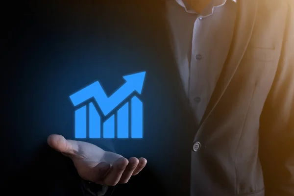 Businessman man holding a graph with positive profits growth. plan graph growth and increase of chart positive indicators in his business.more profitable and growing