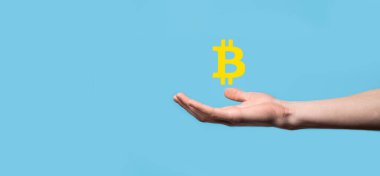 Mavi arka planda Bitcoin ikonu tutan bir erkek el. Bitcoin Şifreleme Dijital Bit Parası BTC Para Birimi Teknolojisi İnternet Konsepti