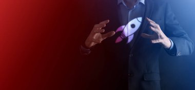 Boş bir iş. Siyah arka planda takım elbiseli bir işadamı ellerini koruyucu bir şekilde tutar. Bakım ve himaye jesti.