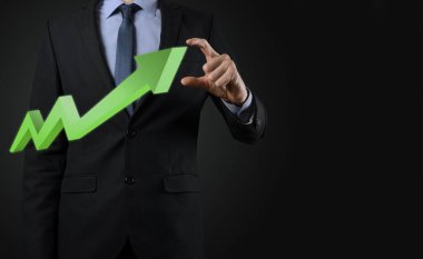 İş adamı artan ekran grafiği, pozitif büyüme ikonu okları üzerinde duruyor. Yaratıcı iş grafiğine yükselen oklarla işaret ediyor. Finansal, ticari büyüme kavramı.