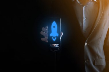 Girişim konsepti, Tablet ve simge roketi tutan İşadamı ekrandan koyu arkaplanda ağ bağlantısı ile fırlıyor ve yükseliyor