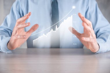 İş adamı elinde pozitif kar artışı olan bir grafik tutuyor. Grafik büyümesi ve grafik artışı işlerinde olumlu göstergeler. Daha kârlı ve büyüyen.