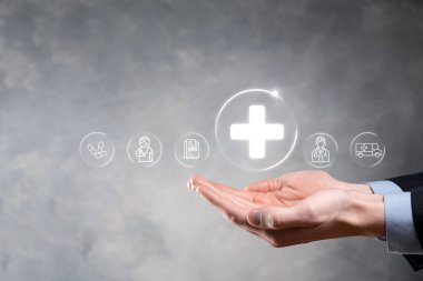 İş adamının elinde sanal ve tıbbi ağ bağlantısı simgeleri var. Covid-19 salgını insanları bilinçlendirir ve sağlık hizmetlerine dikkat çeker. Doktor, belge, ilaç, ambulans, hasta ikonu