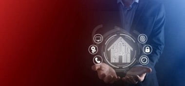 İş adamı ev ikonunu tutuyor. Marketin ev kontrollü, akıllı ev ve ev otomasyon uygulaması konsepti. PCB tasarımı ve akıllı telefonu olan kişi. Yenilik teknolojisi internet ağı kavramı