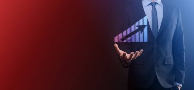 Holografik grafikler ve borsa istatistikleri tutan işadamı kâr elde ediyor. Büyüme planlama ve iş stratejisi kavramı. İyi ekonomi formunun dijital ekran görüntüsü