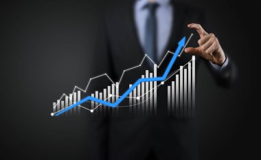 Holografik grafikler ve borsa istatistikleri tutan işadamı kâr elde ediyor. Büyüme planlama ve iş stratejisi kavramı. İyi ekonomi formunun dijital ekran görüntüsü
