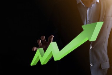 İş adamı artan ekran grafiği, pozitif büyüme ikonu okları üzerinde duruyor. Yaratıcı iş grafiğine yükselen oklarla işaret ediyor. Finansal, ticari büyüme kavramı.