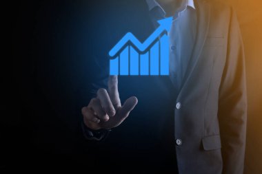 İş adamı elinde pozitif kar artışı olan bir grafik tutuyor. Grafik büyümesi ve grafik artışı işlerinde olumlu göstergeler. Daha kârlı ve büyüyen