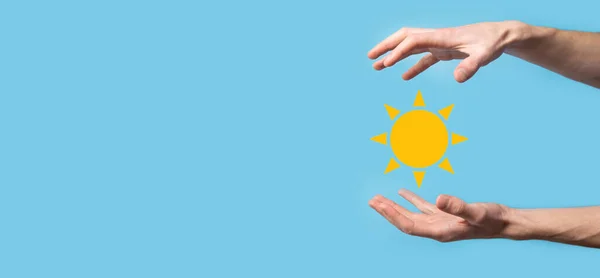 青の背景に手は太陽のアイコンのシンボルを保持しています 環境に優しい技術アプローチ — ストック写真