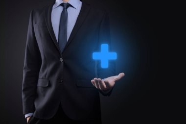 İş adamı, elinde tuttuğu kişi kar, çıkar, gelişme, artı işareti ile temsil edilen CSR gibi olumlu şeyler sunar..