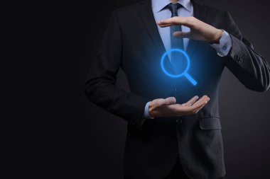 İş adamı ve adam el ele tutuşup cam ikonunu büyütüyorlar. İş dünyası, teknoloji ve internet kavramı