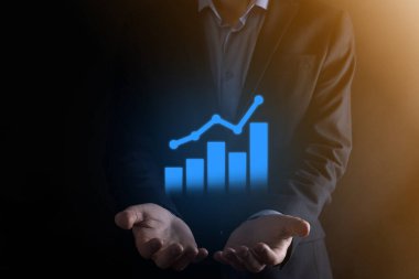 İş adamı elinde pozitif kar artışı olan bir grafik tutuyor. Grafik büyümesi ve grafik artışı işlerinde olumlu göstergeler. Daha kârlı ve büyüyen