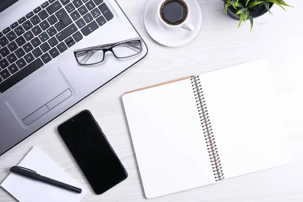 Top view of office work space, wooden desk table with laptop notebook,keyboard,eyeglasses,phone and cup of coffee.With a copy space, flat lay.Mock up.