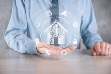 İş adamı ev ikonunu tutuyor. Marketin ev kontrollü, akıllı ev ve ev otomasyon uygulaması konsepti. PCB tasarımı ve akıllı telefonu olan kişi. Yenilik teknolojisi internet ağı kavramı