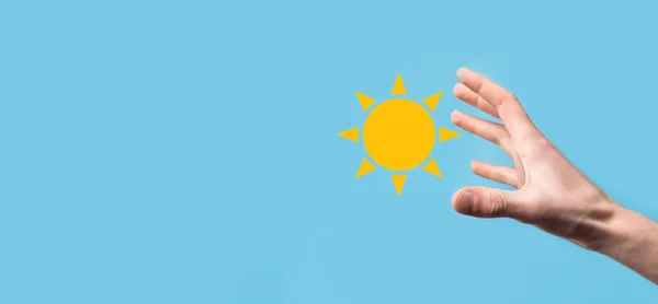 Hånd Blå Bakgrunn Holder Solikonsymbolet Bærekraftig Strømkilde Konseptet Med Strømforsyning – stockfoto