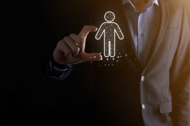 İş adamı, karanlık ses tonunda bir ikon tutuyor. İnsan Kaynakları İnsan Kaynakları, Teknoloji İşletmeleri İşe Alma, İşe Alma, Takım Binası. Örgüt yapısı kavramı.