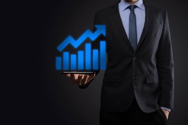 İş adamı artan ekran grafiği, pozitif büyüme ikonu okları üzerinde duruyor. Yaratıcı iş grafiğine yükselen oklarla işaret ediyor. Finansal, ticari büyüme kavramı.