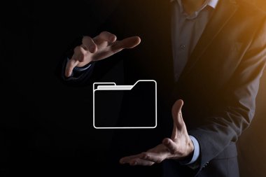 İş adamı dizin simgesini tutuyor. Belge Yönetim Sistemi veya modern bilgisayar bilişim danışmanı tarafından kurulmuş DMS yönetici dosyaları ve kurumsal dosyaları arıyor. İş işleme