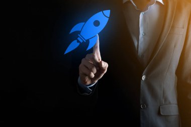 Soyut dijital roket ikonu taşıyan iş adamı konsepti fırlatılıyor ve yükseliyor.