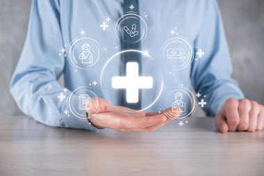 İş adamının elinde sanal ve tıbbi ağ bağlantısı simgeleri var. Covid-19 salgını insanları bilinçlendirir ve sağlık hizmetlerine dikkat çeker. Doktor, belge, ilaç, ambulans, hasta ikonu